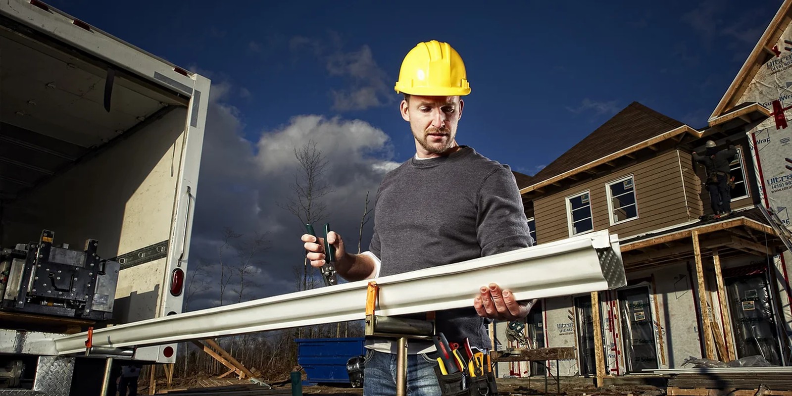 Installateur de gouttières en aluminium sans joint en pleine pose sur un chantier résidentiel à Prévost